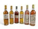 several bottles of wine are lined up on a white surface
