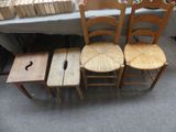 trois chaises en bois et une table sur laquelle sont posés des livres