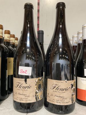 plusieurs bouteilles de vin sont alignées sur une étagère