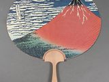 a fan that has a picture of a mountain in the background