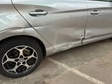 a silver car that has been damaged and is parked in a parking lot