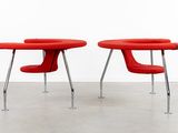 two red chairs sitting next to each other in a room