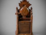 an old wooden chair with a clock on top of it