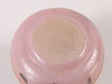 a pink vase sitting on a table with a white background