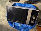 a microwave sitting on a blue bag on the floor