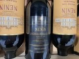 three bottles of wine are sitting on a shelf in a store