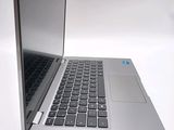 a silver laptop with a black keyboard on a white surface