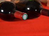 two bottles of wine sitting on a red cloth