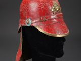 a red helmet with gold accents on a mannequin head