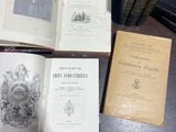 Plusieurs vieux livres sont posés sur une table, à côté d'une pile de vieux livres