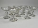 six clear wine glasses sitting on top of each other on a table