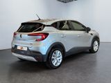the rear end of a silver car in a white room
