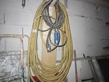 a bunch of wires hanging on a wall in a garage