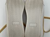 the soles of a pair of white shoes with a yellow strap