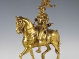 an antique bronze statue of a man on a horse with a hat on
