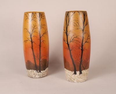deux vases décorés d'arbres, posés sur une table