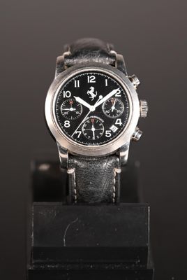 a close up of a watch on a black stand on a black surface