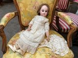 a doll that is sitting on a chair in a room