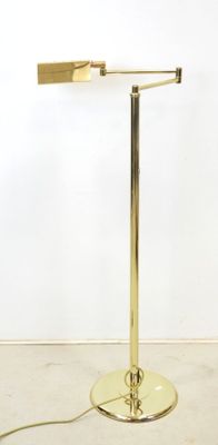a gold table lamp with a white wall behind it