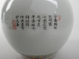 a white vase with chinese writing on it on a table