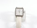 une montre-bracelet blanche avec un bracelet blanc posée sur une surface blanche