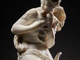 a white marble statue of a woman holding a bird