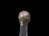 a glass bottle with a silver lid on a table