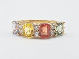 un gros plan sur une bague en or jaune sertie de pierres multicolores