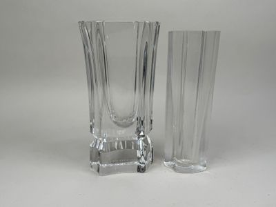 une paire de vases en verre transparent posés sur une surface blanche