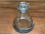 a small glass vase on a table with a wooden surface