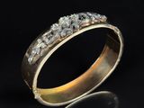 un gros plan d'une bague en or sertie de diamants sur fond noir