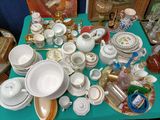 une table bleue sur laquelle sont posés de nombreux plats et tasses