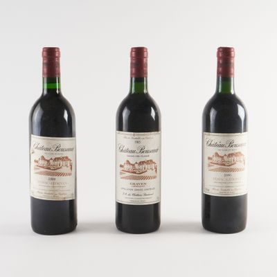 trois bouteilles de vin rouge sont alignées sur une surface blanche