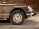 a brown car parked in front of a brick wall