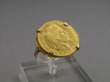 une image représentant une bague en or sur laquelle repose une pièce d'or