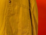 yellow jacket hanging on a hanger against a red wall