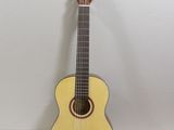 an acoustic guitar sitting on top of a table next to a book