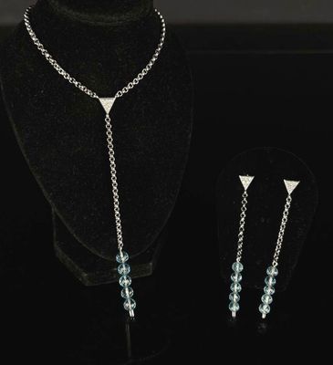 silver plated necklace and earrings with blue crystals on a black mannequin
