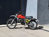 a red dirt bike parked on the side of the street