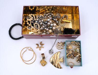une boîte en bois remplie de bijoux variés, posée sur une surface blanche