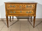 a small wooden chest of drawers on a tiled floor