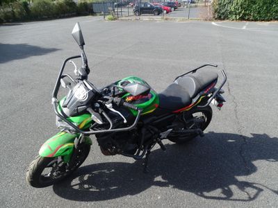 une moto verte et noire garée sur un parking