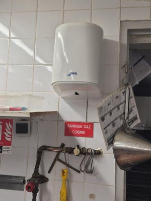 a tank on the wall of a kitchen that has a sign on it