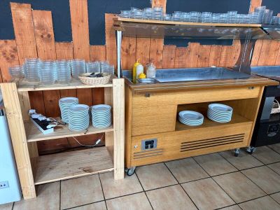 un plan de travail sur lequel sont posées des tasses et des assiettes, dans la cuisine