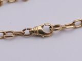 a close up of a gold chain on a white surface