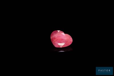 un diamant rose en forme de cœur sur un fond noir