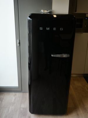 un petit réfrigérateur noir posé dans un coin de la cuisine
