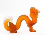 a glass figurine of a dragon on a white surface