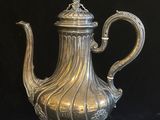 une cafetière en argent sur fond noir, avec un fond noir