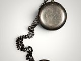 a silver pocket watch with a chain around it